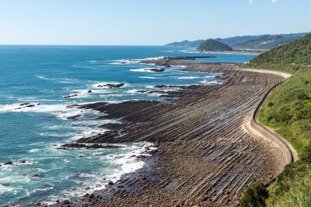 Rocky shoreline of the Nichinan coast, with rows of wave-cut rock stretching into the sea